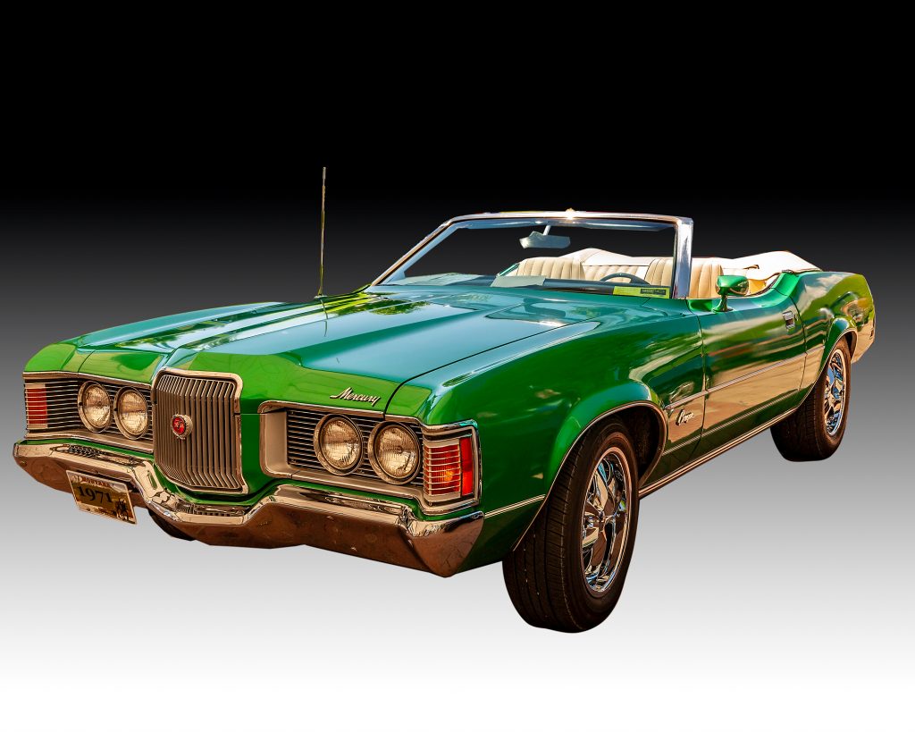 A bright green 1971 Mercury Cougar Convertible with white upholstery.