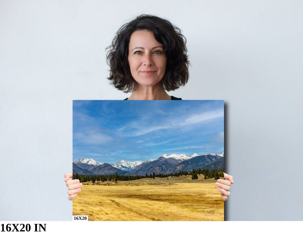 A 16x20" print of the photo "Looking Into the Bob Marshall Wilderness" as held by a woman.