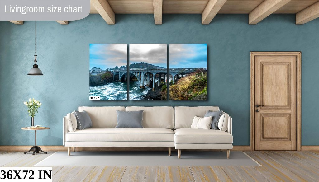 A three panel triptych of the Depoe Bay Bridge hanging above a large couch;
