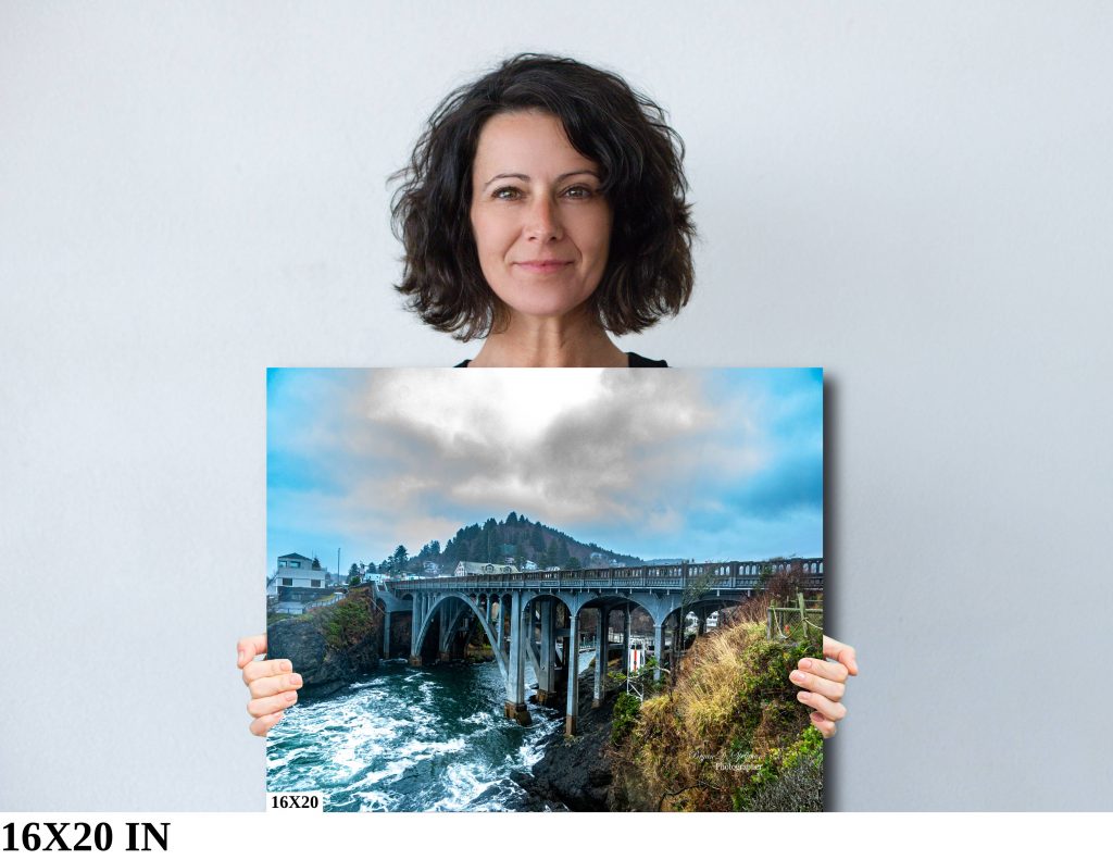 A woman holding a 16x20 print of the Depoe Bay Bridge

